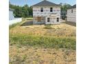Exterior view of a new home construction featuring a yard with wildflowers and neighboring homes at 384 Hopewell Branch Ct, Smithfield, NC 27577