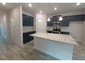 View of kitchen with dark blue cabinets, stainless steel appliances, light gray backsplash and large white island with a sink at 384 Hopewell Branch Ct, Smithfield, NC 27577