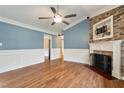 Spacious living room features hardwood floors, fireplace with stone accent wall, and ample natural light at 408 Teal Lake Dr, Holly Springs, NC 27540