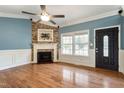 Bright living room with a fireplace, hardwood floors, and large windows offering neighborhood views at 408 Teal Lake Dr, Holly Springs, NC 27540