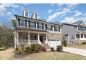 Charming two-story home with a landscaped yard, inviting front porch, and a two-car garage at 420 Cahors Trl, Holly Springs, NC 27540