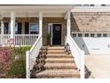 Inviting front entrance with brick steps, white railings, and a decorative wreath on the front door at 420 Cahors Trl, Holly Springs, NC 27540