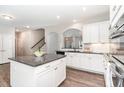 Bright kitchen features white cabinets, granite countertops, an island and stainless steel appliances at 420 Cahors Trl, Holly Springs, NC 27540