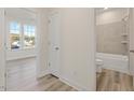 Hallway view of bathroom with tiled shower and separate room with commode at 426 Adams Pointe Ct, Angier, NC 27501