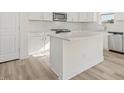 Kitchen island featuring light countertop, white cabinetry, and stainless steel dishwasher at 426 Adams Pointe Ct, Angier, NC 27501
