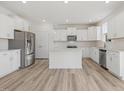 Bright, open kitchen with white cabinetry, stainless steel appliances, and wood-look flooring at 426 Adams Pointe Ct, Angier, NC 27501