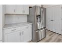 Close-up of kitchen with stainless steel refrigerator, white cabinets and light countertops at 426 Adams Pointe Ct, Angier, NC 27501