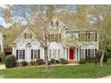 Inviting two-story home features a well-kept lawn, a vibrant red front door, and traditional black shutters at 4313 Branchwood Dr, Durham, NC 27705