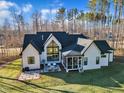 Aerial view of a modern home with a screened porch, patio, and spacious backyard at 472 Stonecrest Way, Pittsboro, NC 27312
