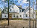 Charming white farmhouse with board and batten siding, set among mature trees at 494 Terry Rd, Hillsborough, NC 27278