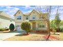 Inviting two-story home with a well-maintained lawn, an attached garage and a quaint front porch at 504 Prince Dr, Holly Springs, NC 27540