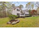 Landscaped front yard featuring a stone planter bed, lush green lawn, and mature trees at 537 Chatham Dr, Chapel Hill, NC 27516