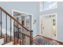 Bright foyer featuring a front door and a staircase with wood and wrought iron railings at 6020 Jones Farm Rd, Wake Forest, NC 27587