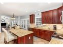 Elegant kitchen with granite countertops, custom wood cabinetry, and an island with seating at 6020 Jones Farm Rd, Wake Forest, NC 27587