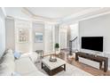 Cozy living room with hardwood floors, white sofa, and a large television at 6020 Jones Farm Rd, Wake Forest, NC 27587
