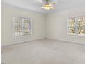 Spacious bedroom with carpet and two large windows, offering natural light and backyard views at 615 Woodland Trl, Louisburg, NC 27549