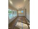 Elegant dining room featuring large windows, a modern chandelier, and wainscoting, awaiting your personal touch at 70 Valebrook Ct, Youngsville, NC 27596