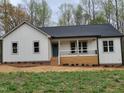 Charming exterior of a newly built home with a welcoming front porch and fresh landscaping at 795 Terry Rd, Hurdle Mills, NC 27541