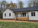 An eye-catching home exterior features a stylish porch, clean lines, and pristine curb appeal at 795 Terry Rd, Hurdle Mills, NC 27541