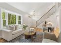 Inviting living room with a large bay window, hardwood floors, and a modern light fixture at 8008 Hollander Pl, Raleigh, NC 27606