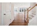 Bright and spacious living room with hardwood floors, and staircase with wood banister and white risers at 9512 Woodriver Dr, Zebulon, NC 27597