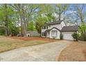 Traditional house with white siding, black shutters, an attached garage and long driveway surrounded by mature trees at 1003 Buckhorn Rd, Garner, NC 27529