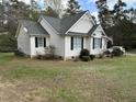 Side view of a white house with black shutters and a green lawn at 103 Kiowa Cv, Louisburg, NC 27549