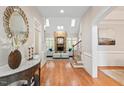 Elegant living room featuring hardwood floors, a stone fireplace, and staircase at 10370 Spaight, Chapel Hill, NC 27517