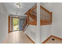 Bright foyer features tiled flooring, a wooden staircase, and a front door allowing for natural light at 104 Stage Line Cv, Louisburg, NC 27549