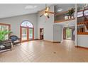 Open living room with tile floors, a soaring ceiling, and access to the outside deck at 104 Stage Line Cv, Louisburg, NC 27549