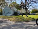 Exterior view of a light-blue one-story home with a well-maintained lawn and mature trees at 109 Plainview Ave, Raleigh, NC 27604