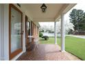 Inviting front porch with white columns, mosaic tile, and a bench overlooking the yard at 1104 W Cole St, Dunn, NC 28334