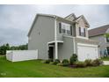 Charming two-story home features a two-car garage, well-maintained lawn, and white fence at 111 Flying Point Ln, Clayton, NC 27520