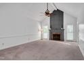 Spacious living room features a vaulted ceiling, brick fireplace, and ample natural light from the french doors at 1117 Country Brooke Dr, Raleigh, NC 27603