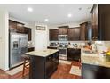 Modern kitchen with granite countertops, stainless steel appliances, island, and wood floors at 1620 Frog Hollow Way, Wake Forest, NC 27587