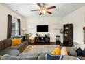 Comfortable living room featuring a ceiling fan, large sofa, and decorative shelves at 1620 Frog Hollow Way, Wake Forest, NC 27587