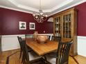 Formal dining room featuring a large wooden table, elegant chandelier, and a classic china cabinet at 1625 Heritage Garden St, Wake Forest, NC 27587