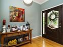 Elegant entryway with hardwood floors, stylish console table, and decorative art leading to the front door at 1625 Heritage Garden St, Wake Forest, NC 27587