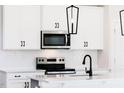 A close up of a well-lit kitchen with white cabinets and stainless steel appliances at 163 Little Creek Dr, Lillington, NC 27546