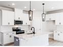 Modern kitchen featuring white cabinets, stainless steel appliances, and a center island with a sink at 163 Little Creek Dr, Lillington, NC 27546