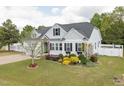 Landscaped front yard with colorful shrubs and tree that accents the light-colored siding and dark shutters at 175 Brazil Nut Ln, Smithfield, NC 27577
