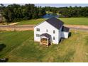 Aerial view showcases the home's back porch, expansive green lawn and pond in the background at 176 Golfview Ave, Benson, NC 27504