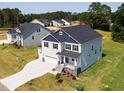Aerial view of a well-maintained two-story home with a three-car garage surrounded by a lush green lawn at 176 Golfview Ave, Benson, NC 27504