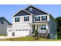 Stylish two-story home with a three-car garage and inviting front porch on a well-manicured lawn at 176 Golfview Ave, Benson, NC 27504