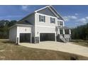 Two-story home featuring a two-car garage, porch, gray siding, and dark shutters set against a bright blue sky at 176 Golfview Ave, Benson, NC 27504