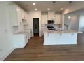 Modern, bright kitchen with white cabinets, stainless steel appliances, and a large island with pendant lighting at 183 Little Crk Dr, Lillington, NC 27546