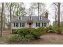 Traditional home with symmetrical facade, dormer windows, red door, and mature shrubbery at 2629 Sweetgum Dr, Apex, NC 27539