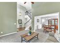 Open-concept living space with high ceilings, carpeted floors, and stairs to the second floor at 2832 Steeple Run Dr, Wake Forest, NC 27587