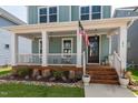 Cozy covered front porch with wood decking and views of landscaped yard at 304 Rivella Dr, Wake Forest, NC 27587
