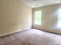 Bright bedroom with neutral walls, plush carpeting, and a large window bringing in natural light at 4616 Silverdene St, Raleigh, NC 27616